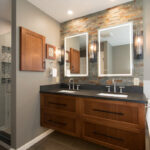 Floating vanity finished in Autumn stain near a large white tub.