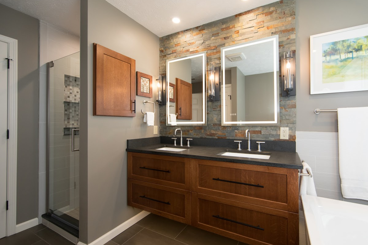 Floating vanity finished in Autumn stain near a large white tub.