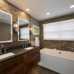 Floating vanity finished in Autumn stain near a large white tub.