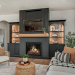 Living room showing couch seating and a fireplace with bookcases on each side.