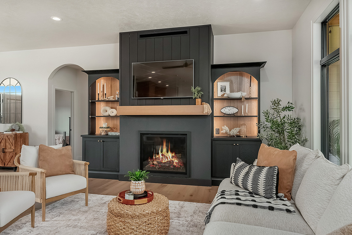 Living room showing couch seating and a fireplace with bookcases on each side.