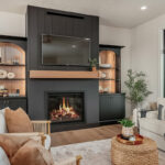Living room showing couch seating and a fireplace with bookcases on each side.