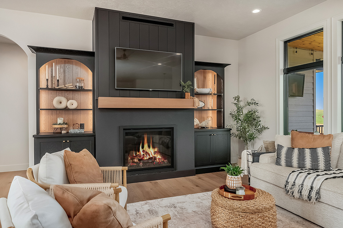 Living room showing couch seating and a fireplace with bookcases on each side.