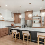 Light brown-stained kitchen cabinets with a white painted wood hood and dark stained island cabinets