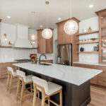 Light brown-stained kitchen cabinets with a white painted wood hood and dark stained island cabinets