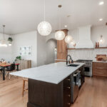 Light brown-stained kitchen cabinets with a white painted wood hood and dark stained island cabinets