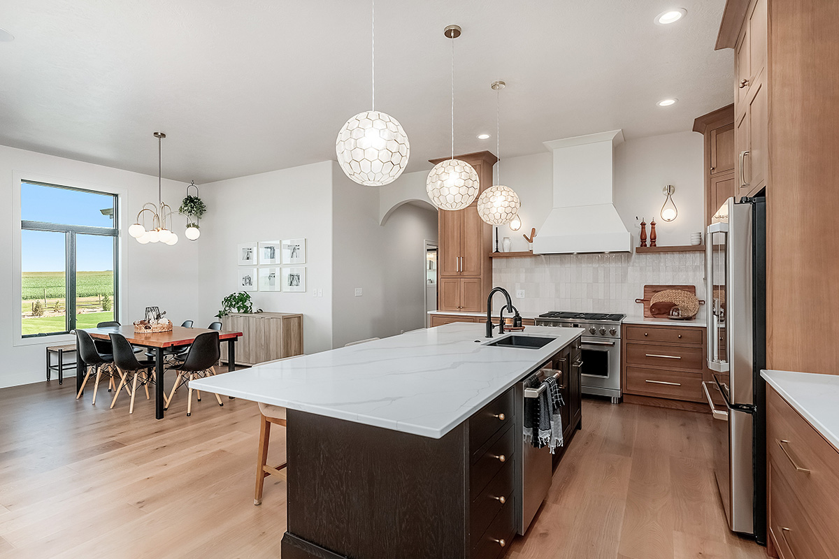 Light brown-stained kitchen cabinets with a white painted wood hood and dark stained island cabinets