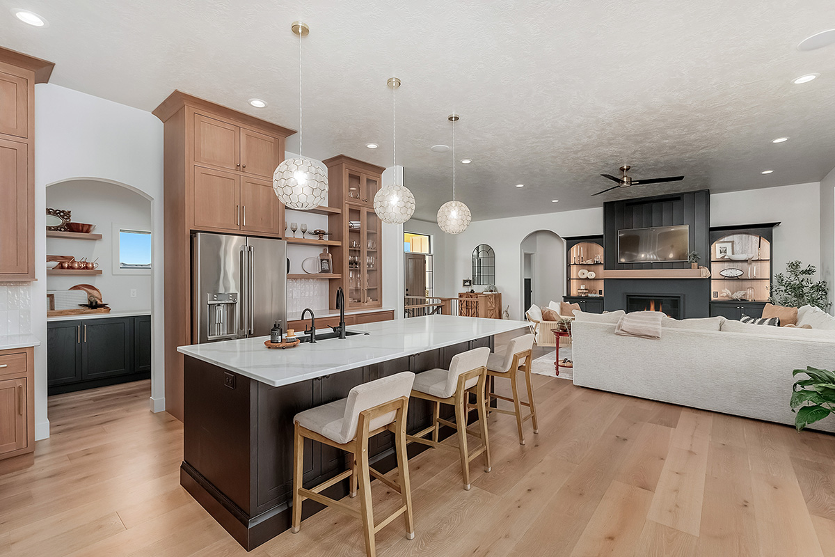 Light brown-stained kitchen cabinets with a white painted wood hood and dark stained island cabinets