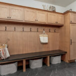 Light brown stained mudroom locker cabinets with dark stained bench seating