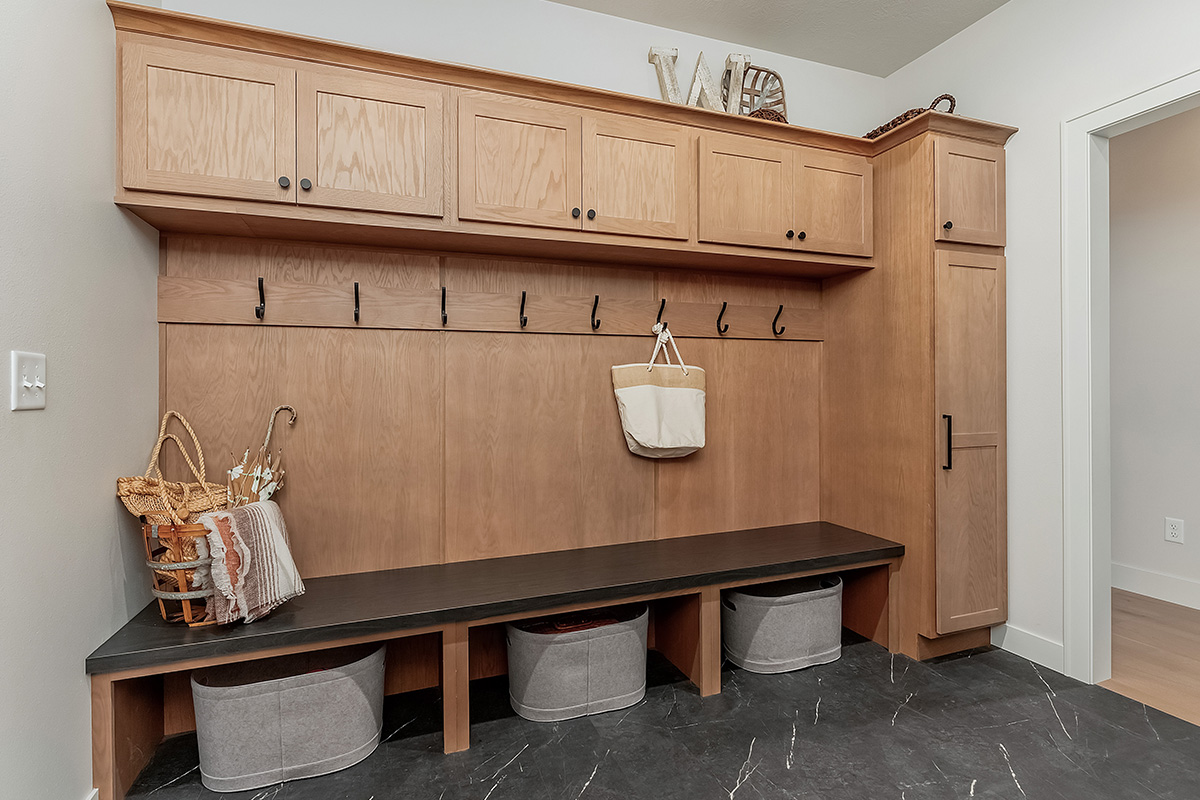 Light brown stained mudroom locker cabinets with dark stained bench seating