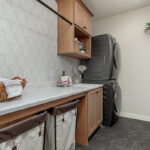 Laundry room cabinets and stacked washer and dryer.