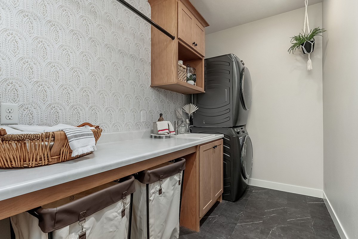 Laundry room cabinets and stacked washer and dryer.