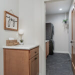 Single light brown stained cabinet separated from the laundry room.