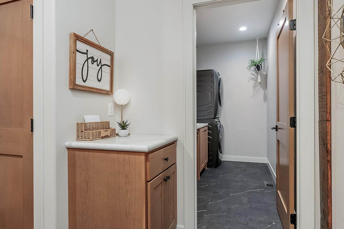 Single light brown stained cabinet separated from the laundry room.