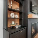 Open shelf bookcase next to a fireplace