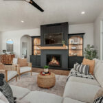 Living room showing couch seating and a fireplace with bookcases on each side.