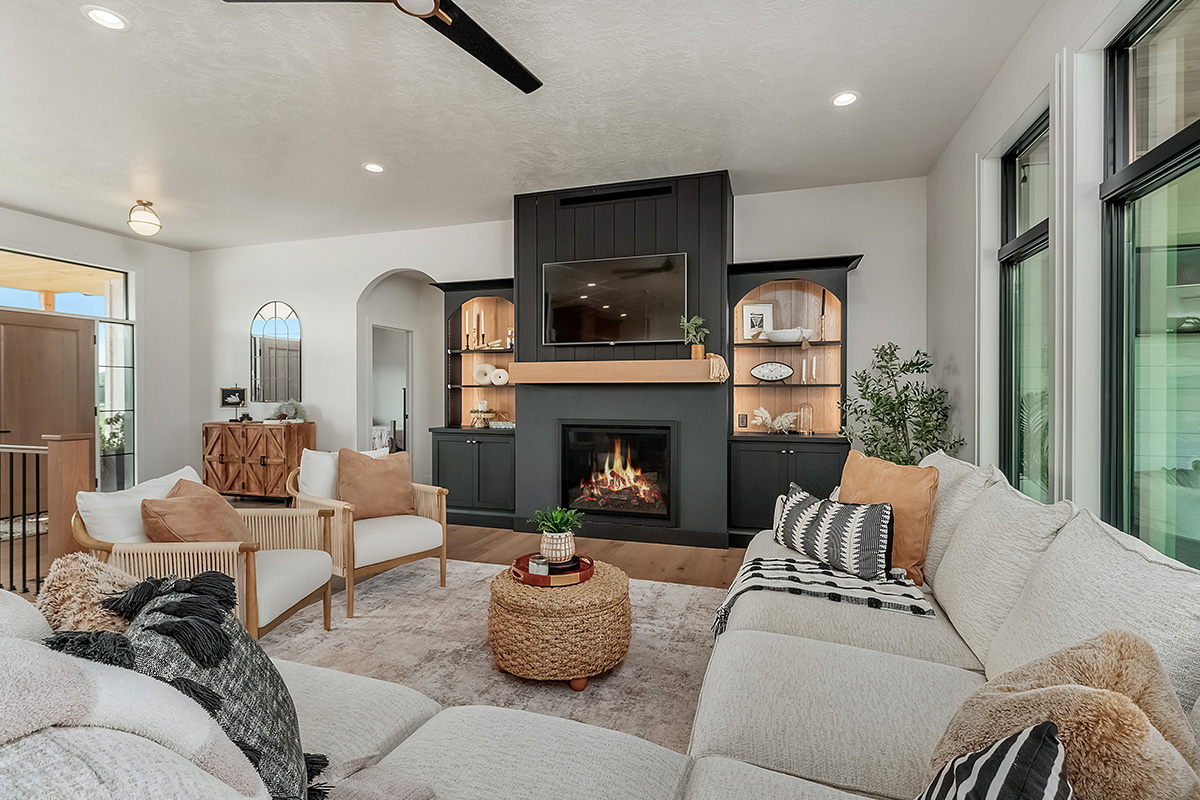 Living room showing couch seating and a fireplace with bookcases on each side.