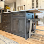 Painted white kitchen perimeter cabinets with brown stained island.