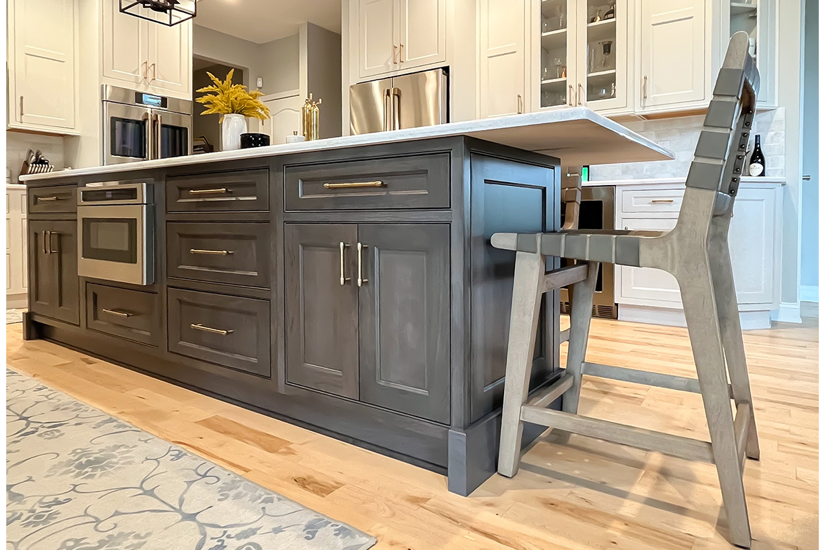 Painted white kitchen perimeter cabinets with brown stained island.