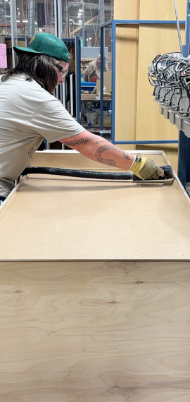 Man applying glue to back of cabinet