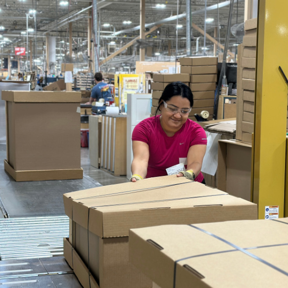 Woman operating a box strap machine