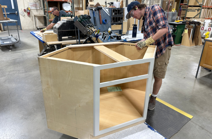 Man working on a corner base cabinet