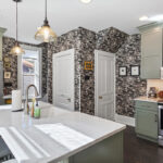 Painted green kitchen cabinets with unique wallpaper