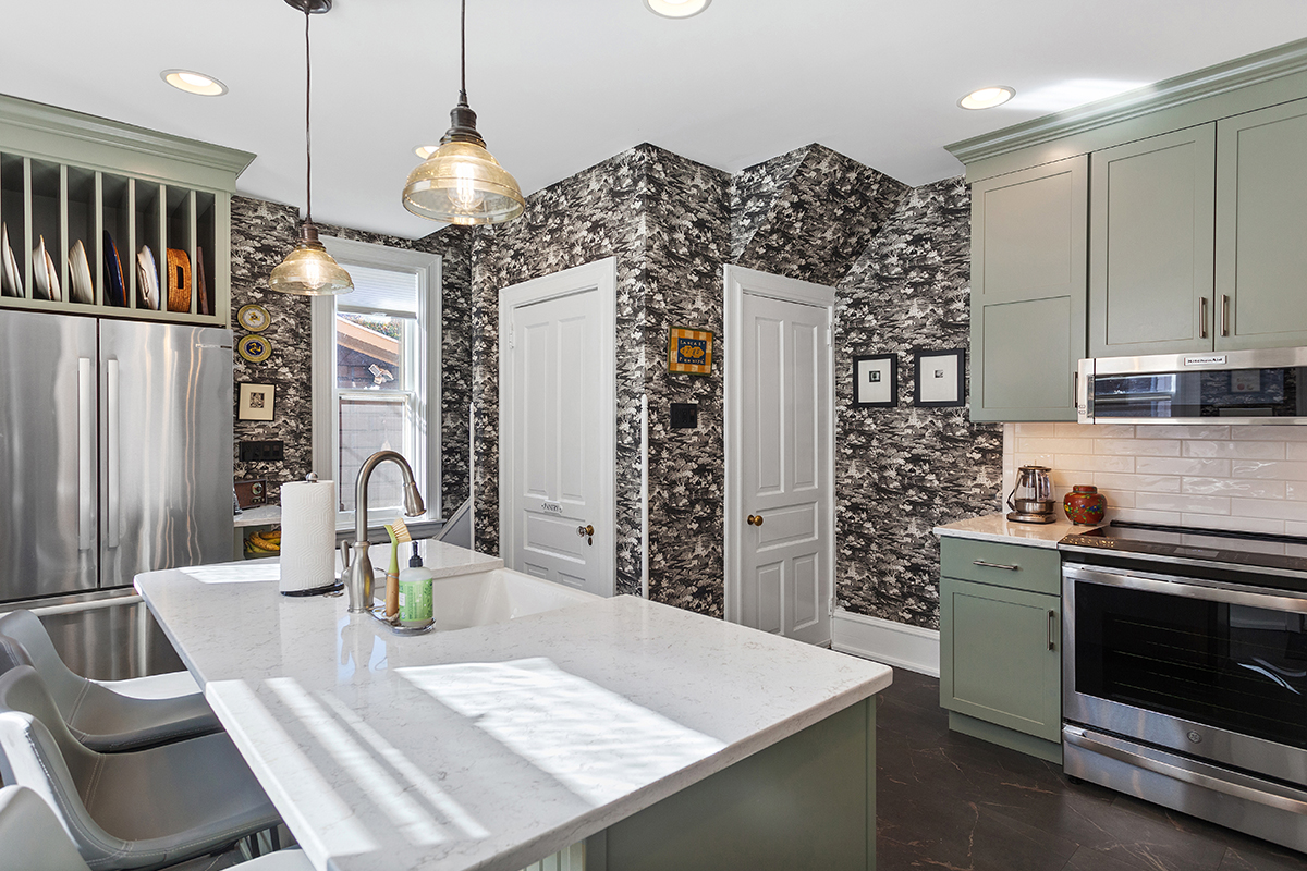 Painted green kitchen cabinets with unique wallpaper