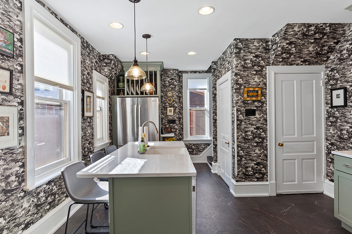 Painted green kitchen cabinets with unique wallpaper