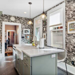 Painted green kitchen cabinets with unique wallpaper