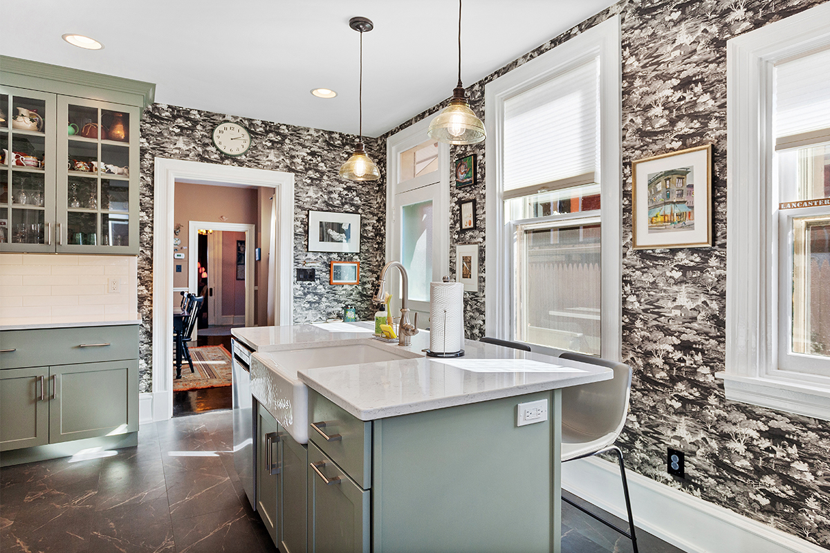 Painted green kitchen cabinets with unique wallpaper