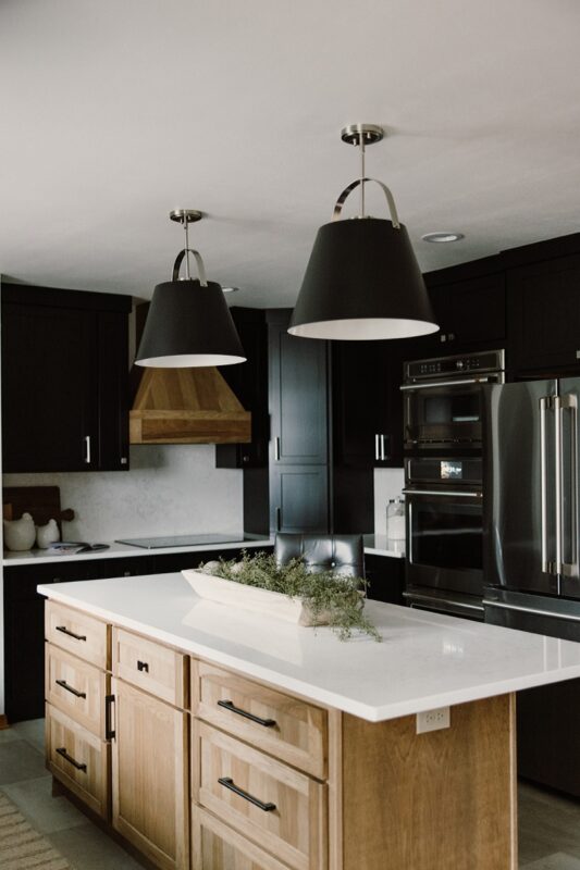 Black painted kitchen cabinets with light brown stained hood and island