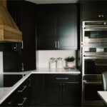 Black painted kitchen cabinets with light brown stained hood and island