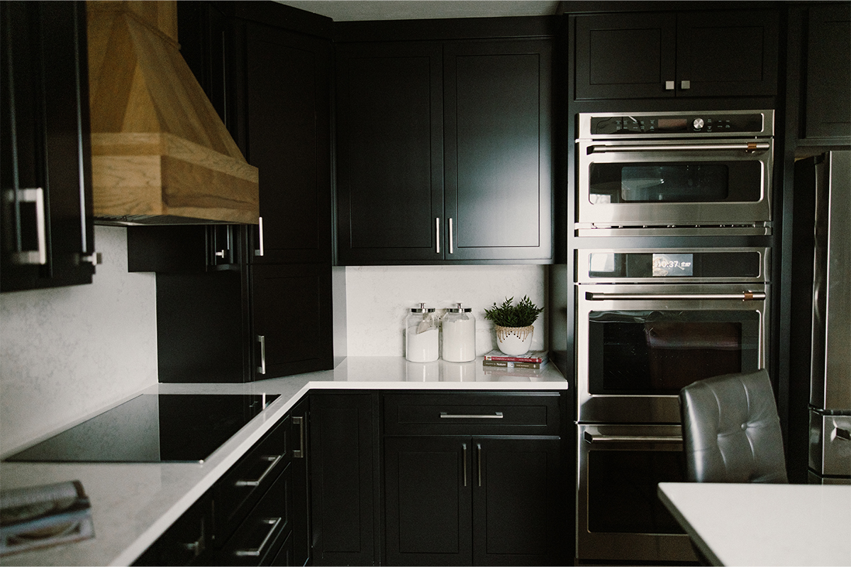 Black painted kitchen cabinets with light brown stained hood and island