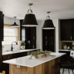 Black painted kitchen cabinets with light brown stained hood and island