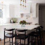 White kitchen with black island seating.