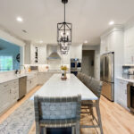 Painted white kitchen perimeter cabinets with brown stained island.