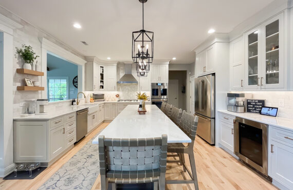 Painted white kitchen perimeter cabinets with brown stained island.