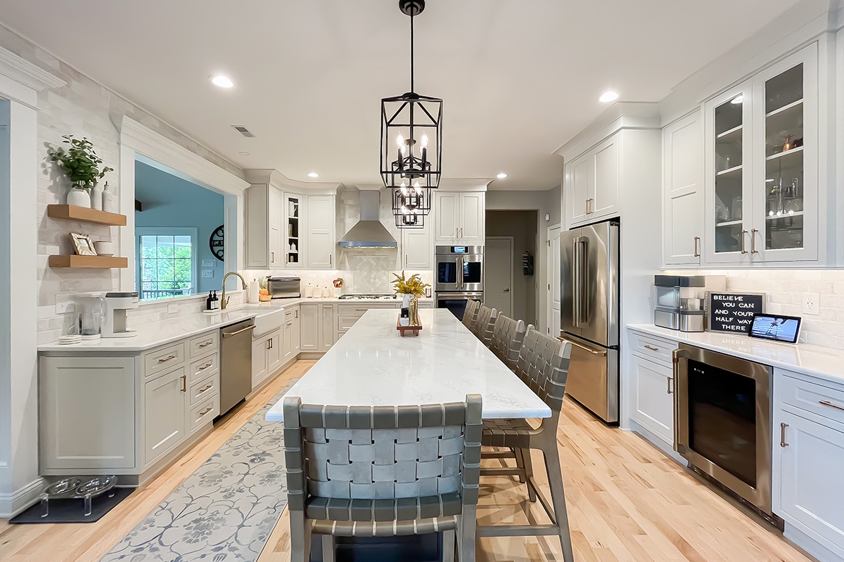 Painted white kitchen perimeter cabinets with brown stained island.