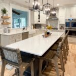 Painted white kitchen perimeter cabinets with brown stained island.