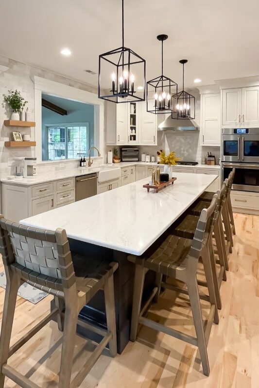 Painted white kitchen perimeter cabinets with brown stained island.