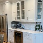 White painted cabinets with stainless steel appliances and wall cabinet with glass doors
