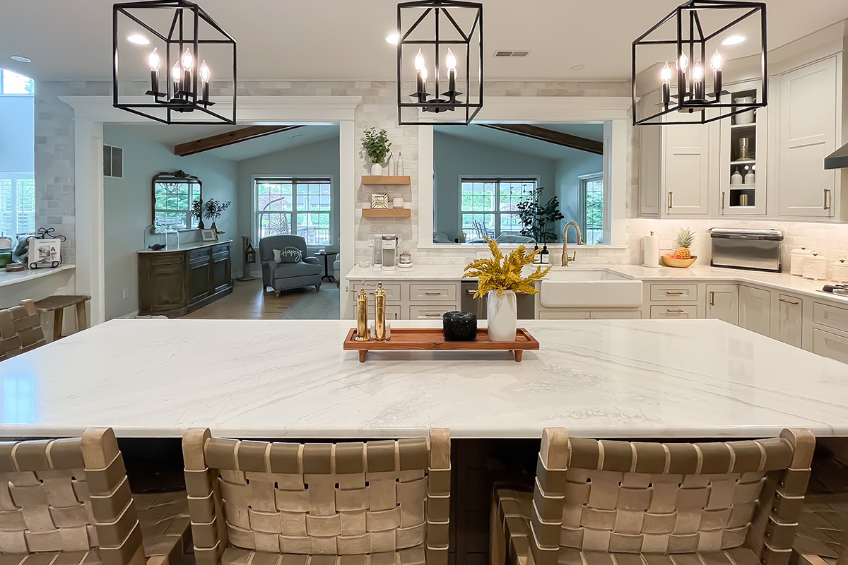 Painted white kitchen perimeter cabinets with brown stained island.