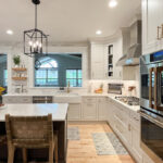 Painted white kitchen perimeter cabinets with brown stained island.
