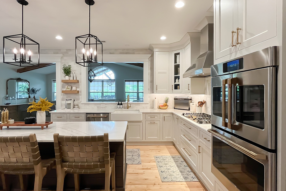 Painted white kitchen perimeter cabinets with brown stained island.