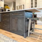 Painted white kitchen perimeter cabinets with brown stained island.