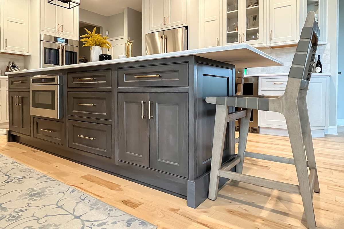 Painted white kitchen perimeter cabinets with brown stained island.