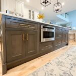 Painted white kitchen perimeter cabinets with brown stained island.