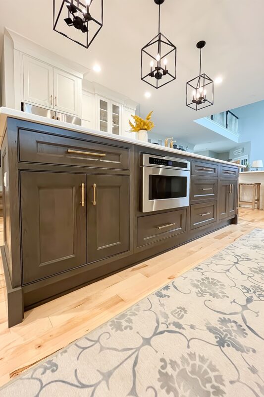 Painted white kitchen perimeter cabinets with brown stained island.