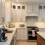 White painted kitchen perimeter cabinets and walnut natural island.